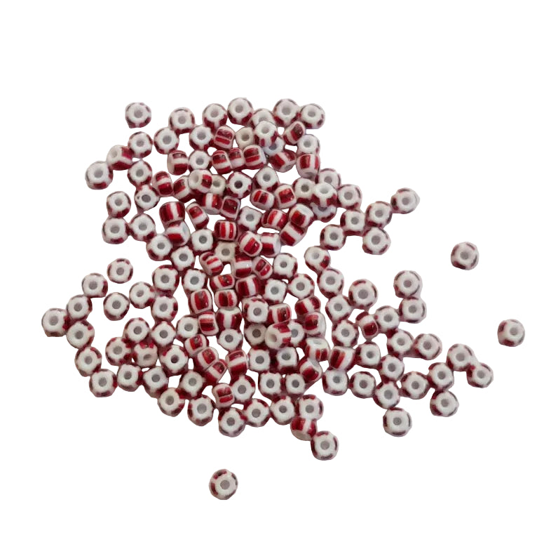 Small red and white beads scattered on a light gray background