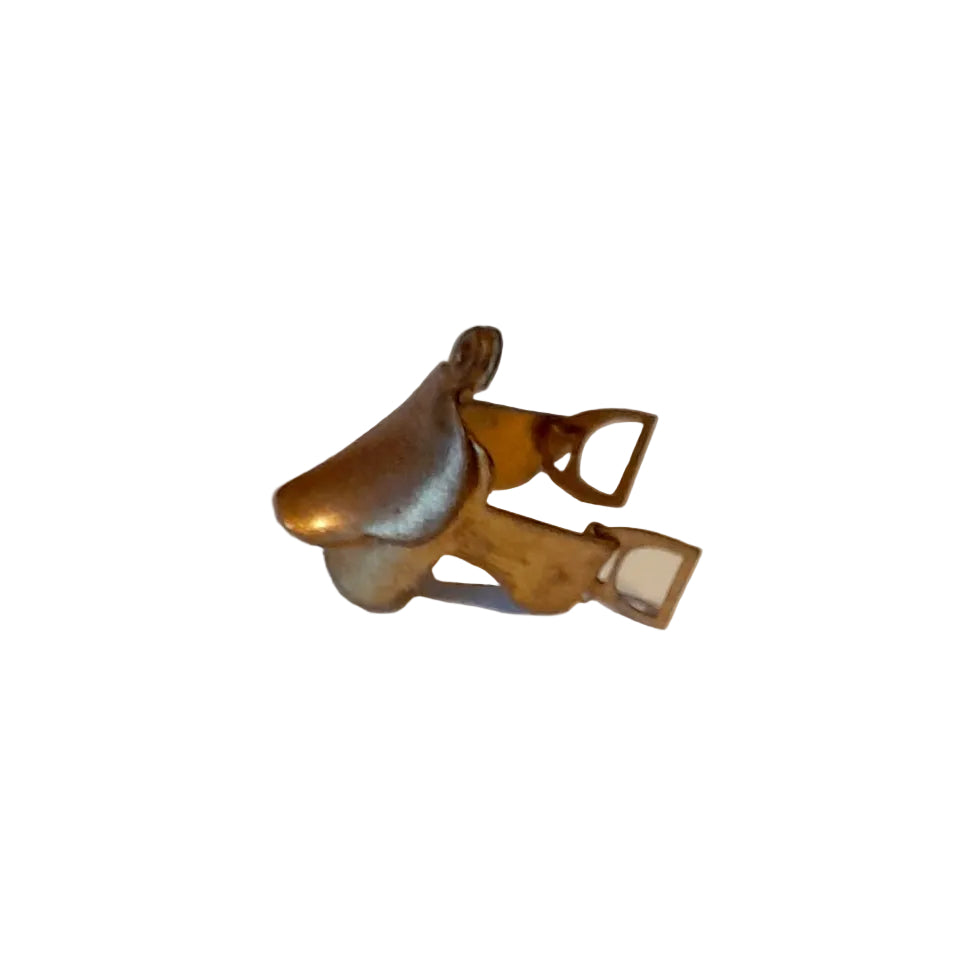 A small brass metal accessory with a curved horse saddle top and looped side detail,