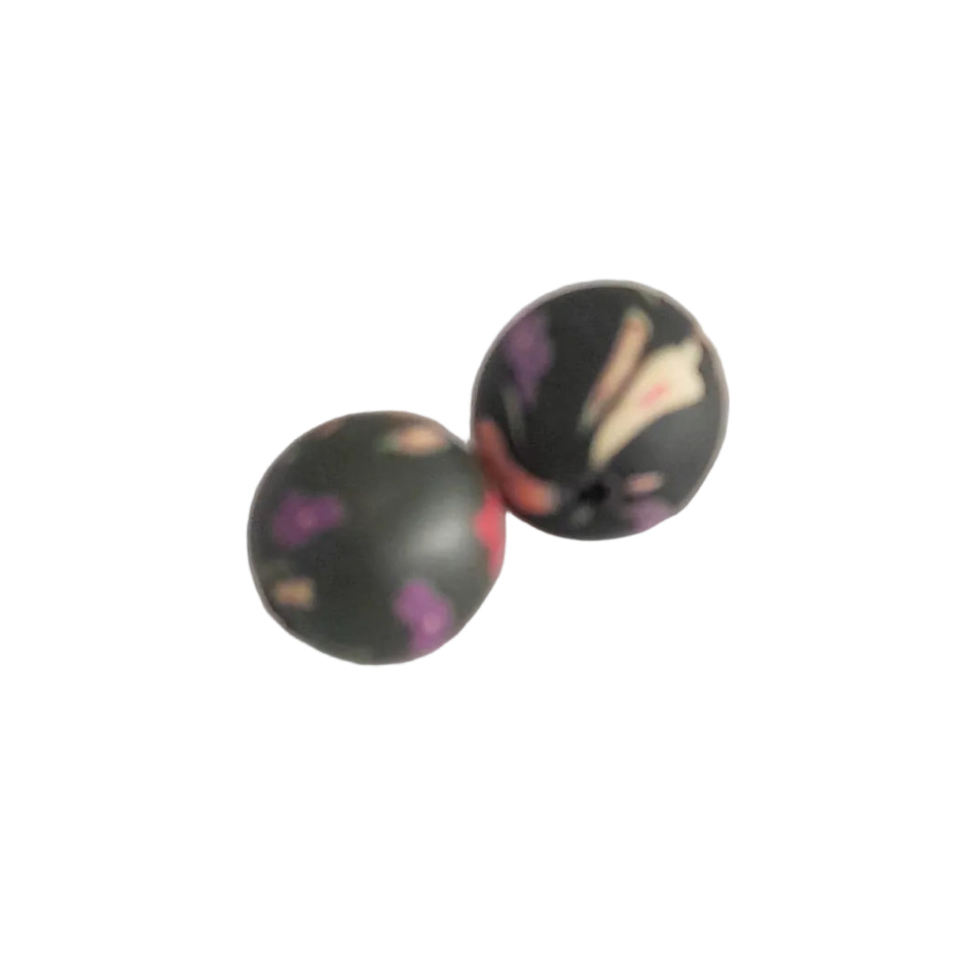 Two round black beads with a marbled pattern of purple, pink, and cream, displayed on a light gray background.