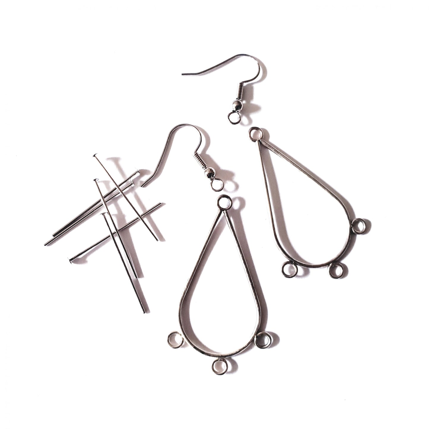 A kit containing earring frames, head pins, and fish hooks for jewelry making, displayed on a white background.