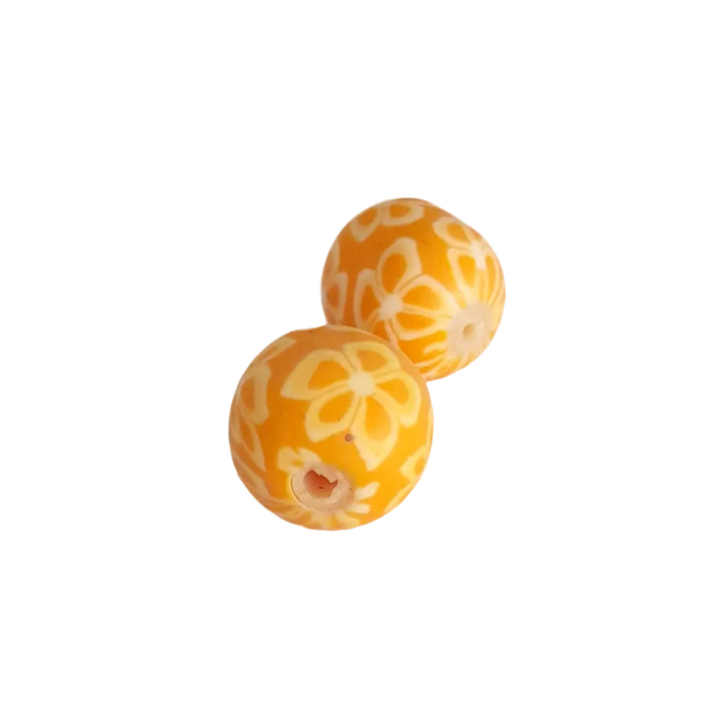 Two round 15mm millefiori yellow-orange beads with a white floral pattern, 