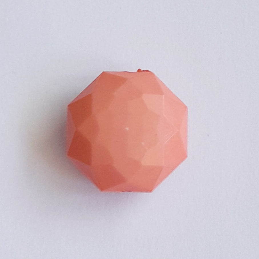 A faceted, octagonal coral-pink bead 25mm