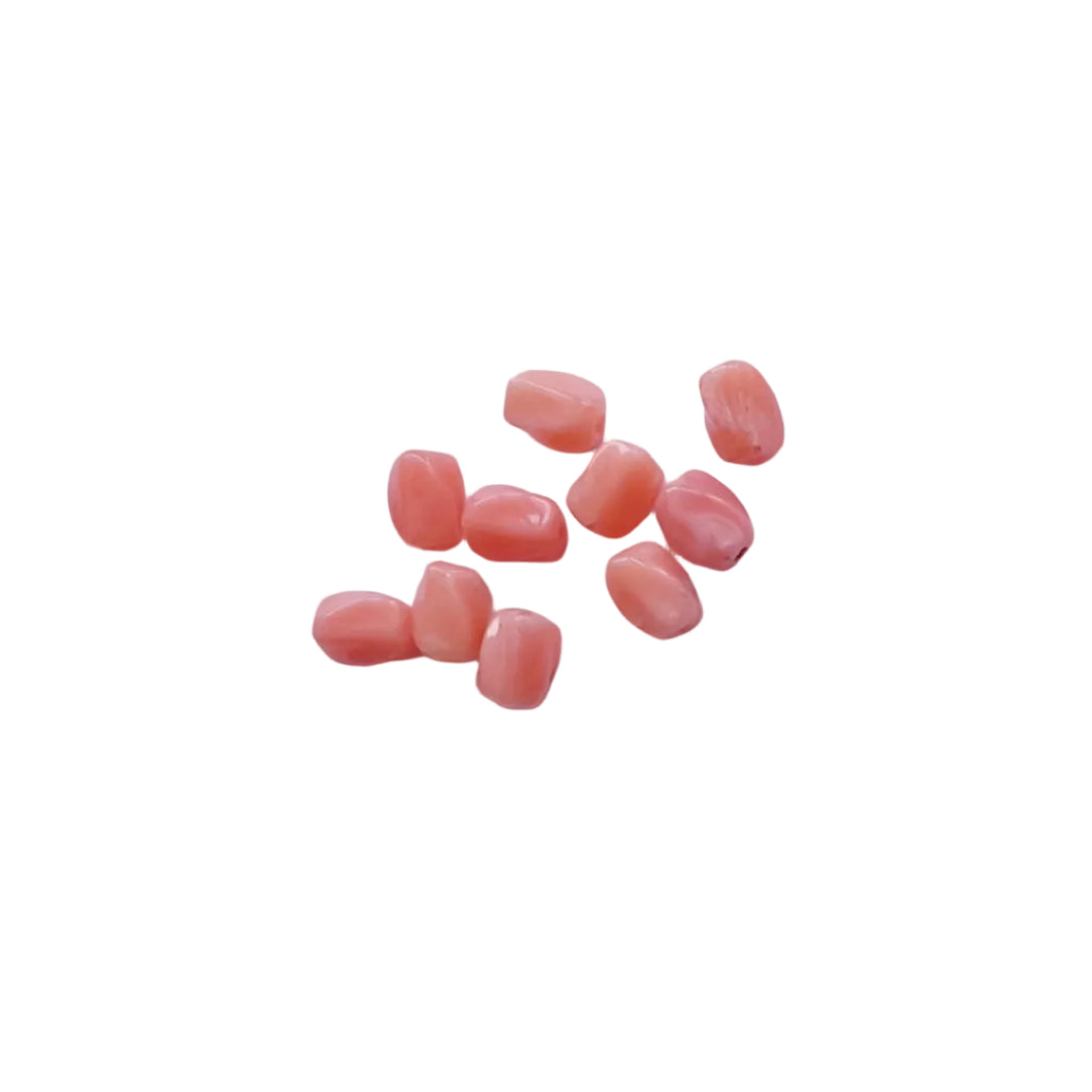 A small cluster of glossy peach-pink oval beads or cabochons arranged on a plain light background.