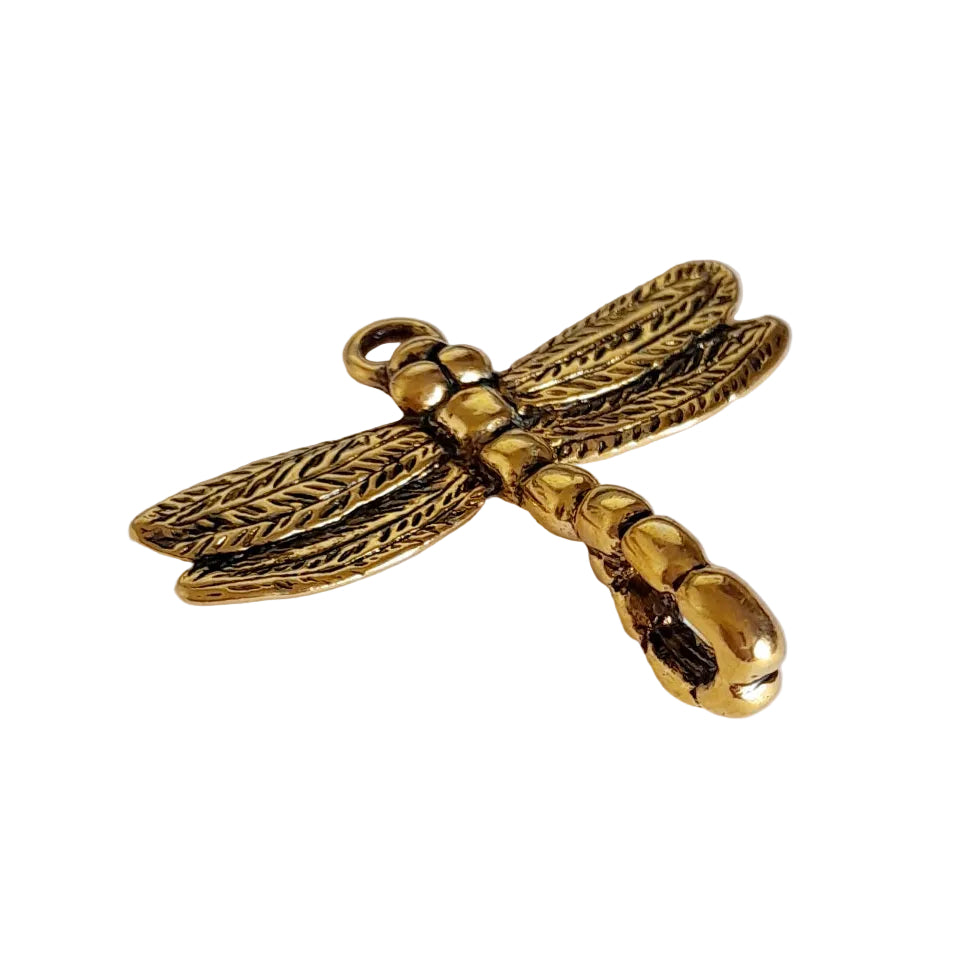 A gold dragonfly pendant charm with detailed textured wings and body