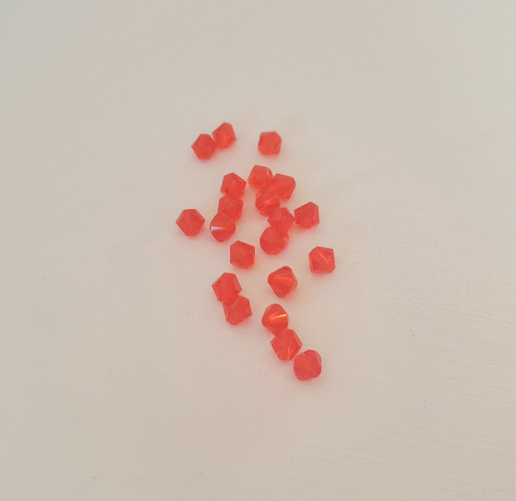 A small cluster of translucent red-orange faceted beads swarovski brand hyacinth 4mm