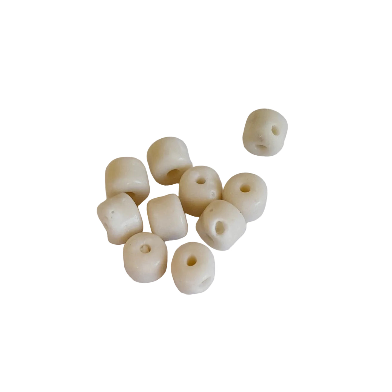 A group of small cylindrical glass beads with a single hole, made to mimic warm off-white material like bone, ivory, or coral