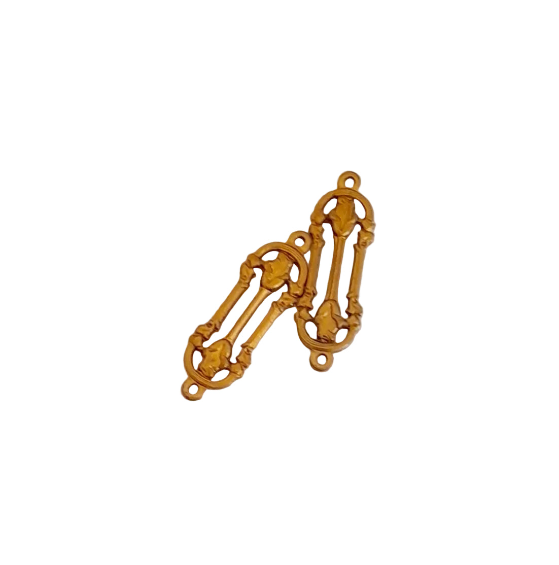 Two antique gold-toned metal scrollwork charms with loop tops, background.
