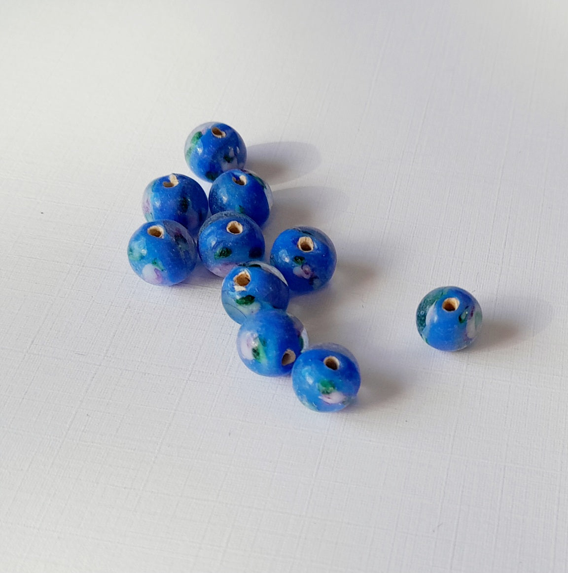 small 8mm round blue glass beads with colourful swirls of green, white, and purple, indian