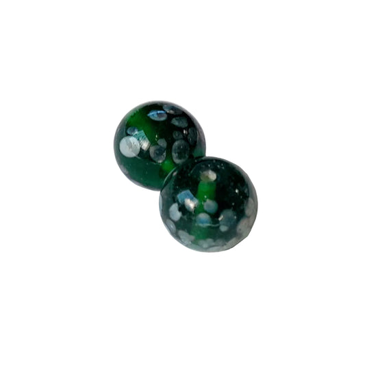 Two round green glass beads with white and dark green speckled patterns