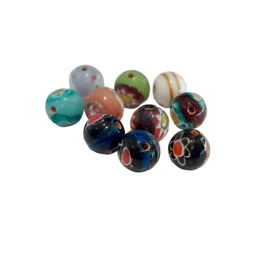 A group of ten colorful glass lampwork beads with various patterns, including swirls, stripes, and floral motifs,