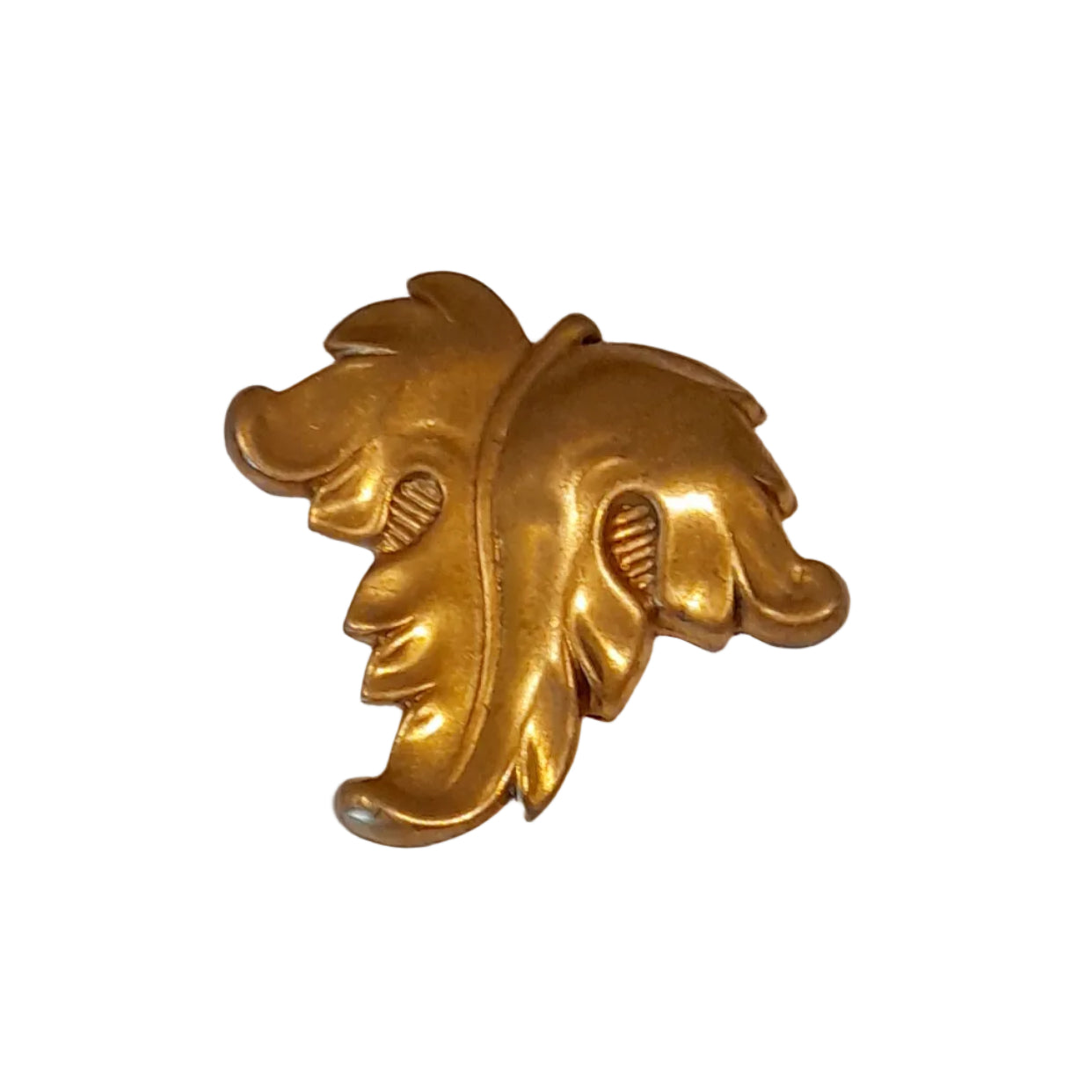 A large gold-toned decorative object with an ornate leaf or acanthus-like sculptural shape, 