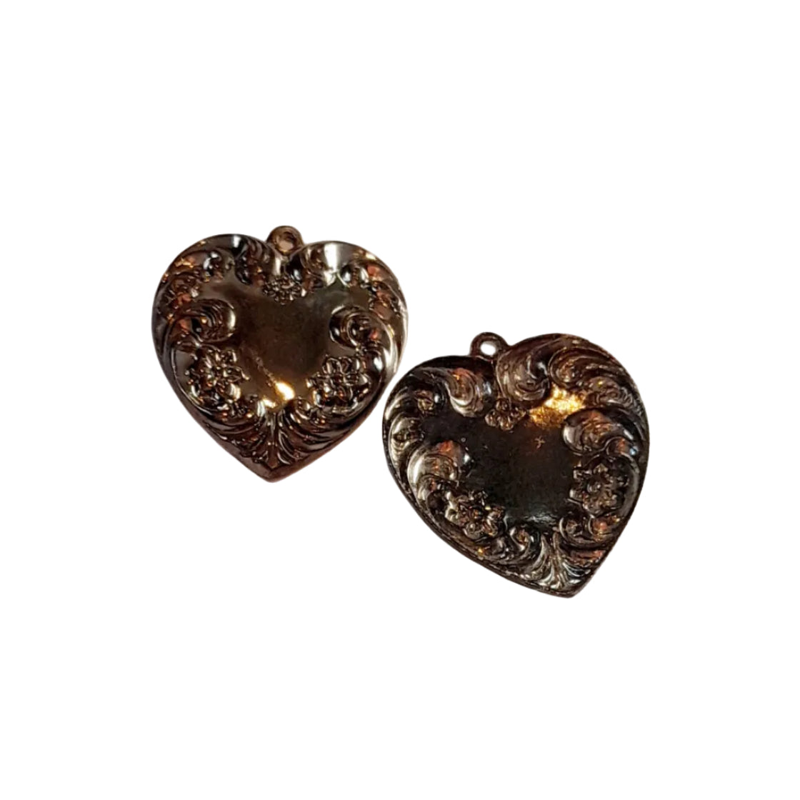 Two heart-shaped black pendants with ornate floral engraving, 