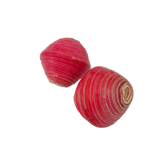 Two small, rounded, striped pink and white objects with a textured, ribbed surface, photographed on a plain off-white background.