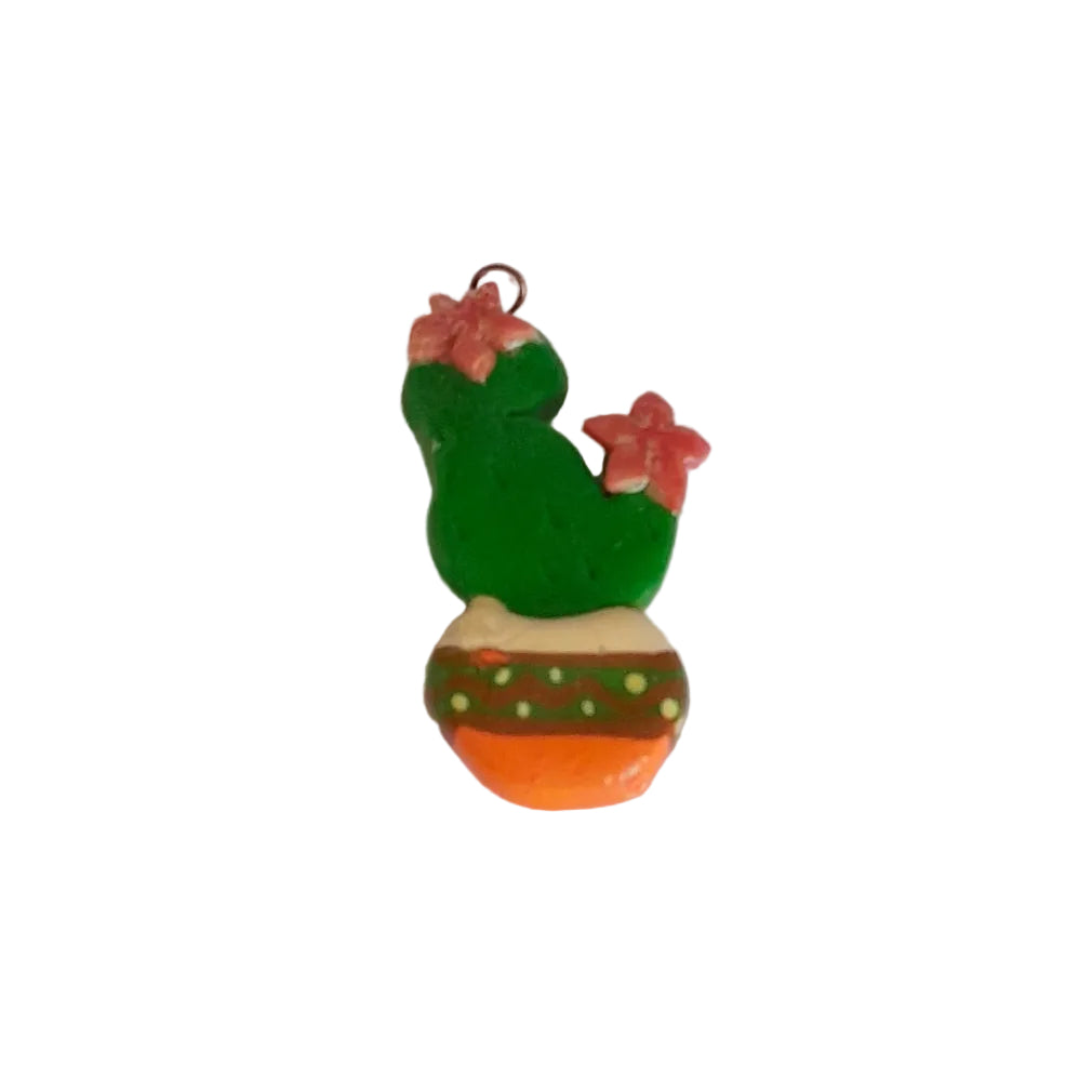 A small handmade cactus charm or pendant with a green body, pink flowers, and an orange pot base, 