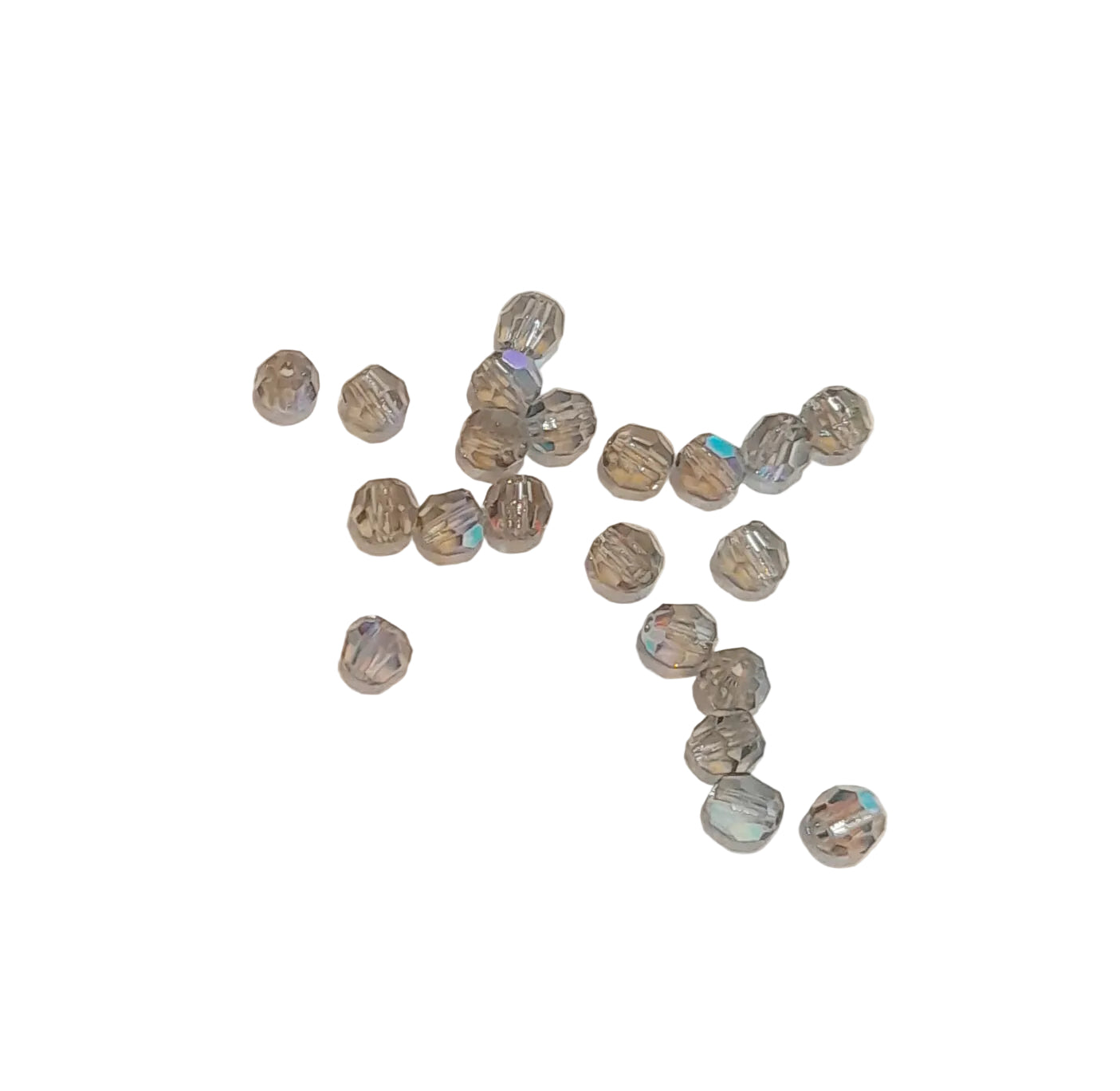 A group of small faceted glass beads with a gray and silver iridescent finish, scattered on a plain off-white background.