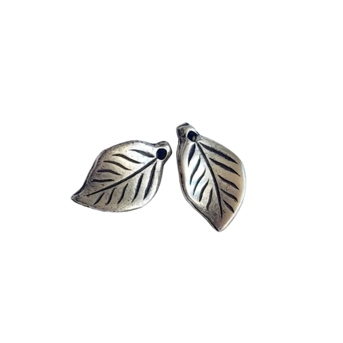 A pair of silver-toned leaf-shaped jewelry charms with engraved leaf veins and small loop holes, 