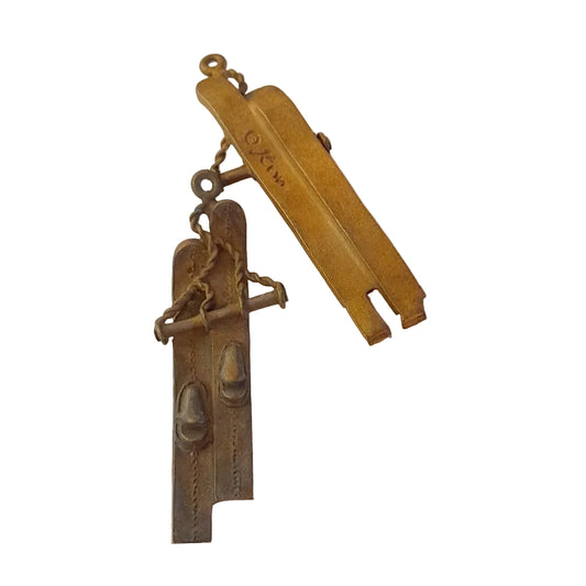 A vintage metal snow boot and strap accessory 
