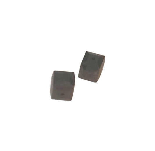 Two small dark gray rectangular blocks with rounded corners, shown on a plain off-white background.