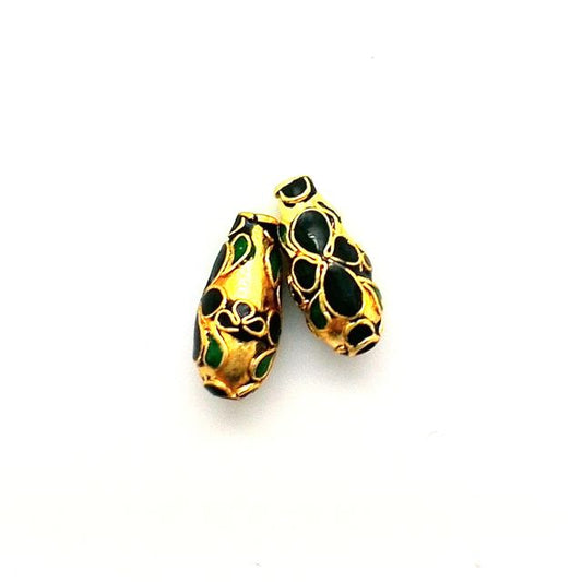 A gold-colored metal bead with a floral design, featuring black jade accents, on a white background.
