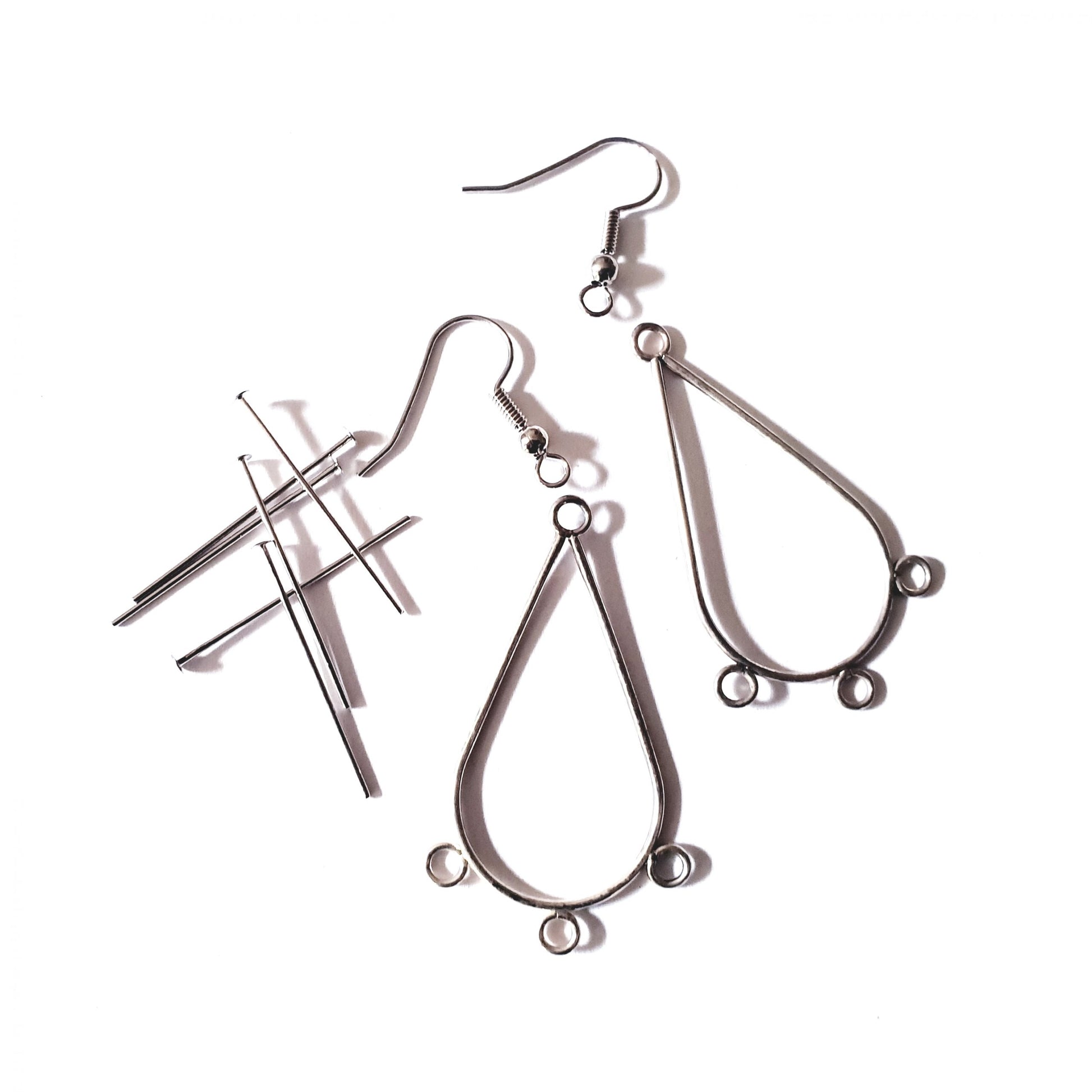 A kit containing earring frames, head pins, and fish hooks for jewelry making, displayed on a white background.