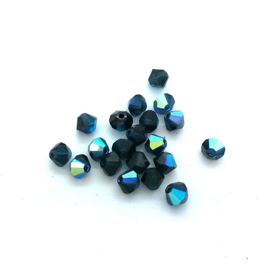 A collection of machine cut Czech Preciosa crystal bicone Montana AB beads in 4mm size with a blue color and multicolored reflective surface.